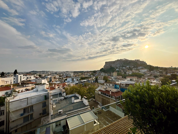 Zicht vanaf een dak op de Akropolis bij zonsondergang