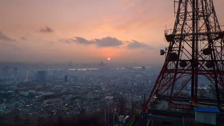Gün batımı şehir panoramasının üzerinde Seoul Kulesi'nin tabanı