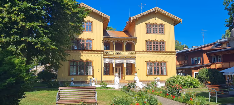 Bahçe içinde oymalı balkonlu sarı ahşap villa