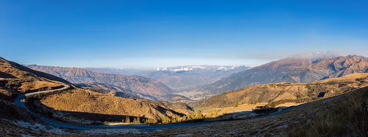 Panorama av Andesfjellene med en dal og fjellvei