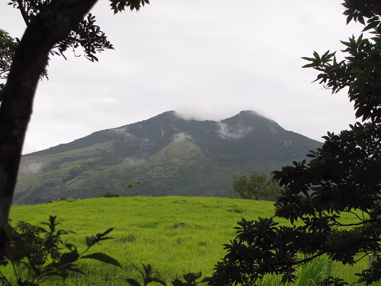 Guanacaste'de yeşil bir tarlanın üzerindeki yanardağ