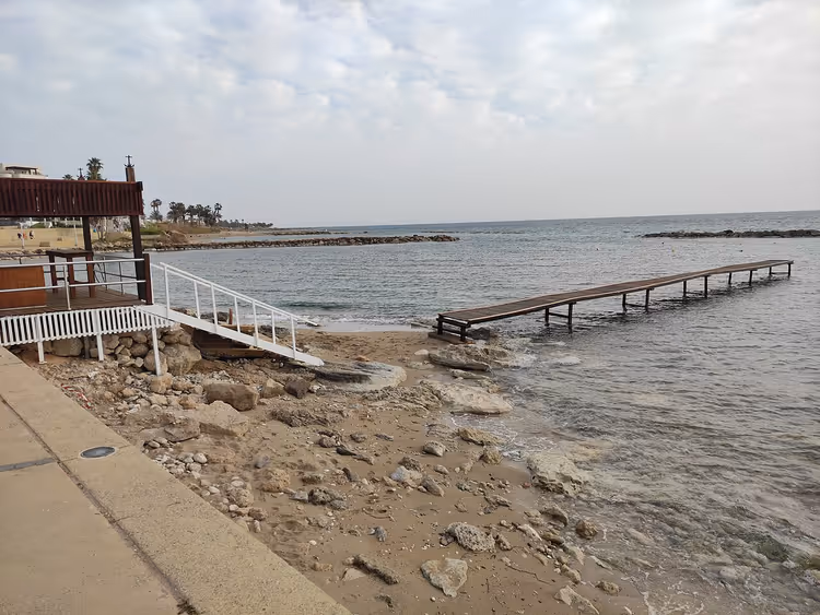 Kıbrıs'ta iskeleli kayalık plaj ve deniz
