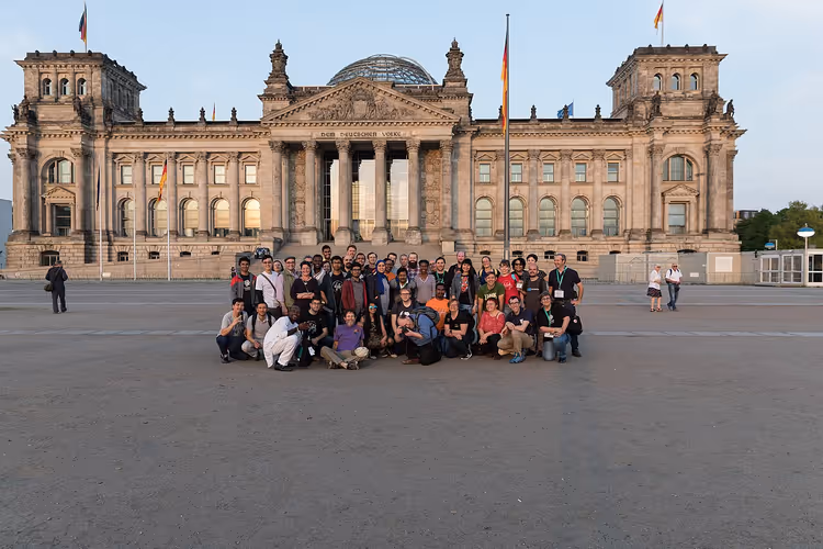 Berlin'de Reichstag binası önünde poz veren bir grup turist