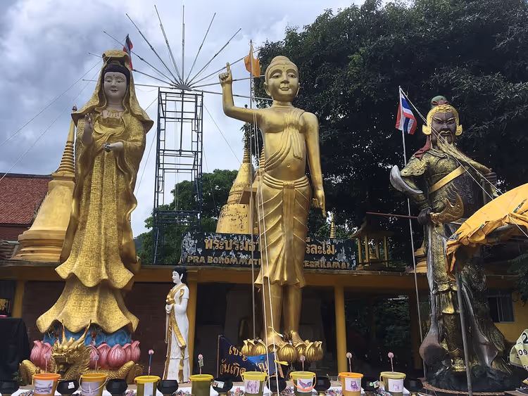 Gyldne statuer av Guanyin, Buddha og en vokter i et tempel