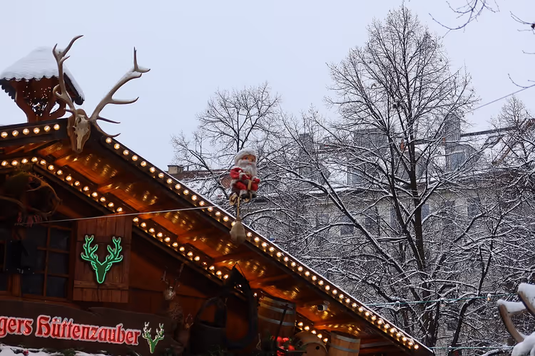 Père Noël suspendu à une corde au-dessus d'un chalet de Noël à Haidhausen