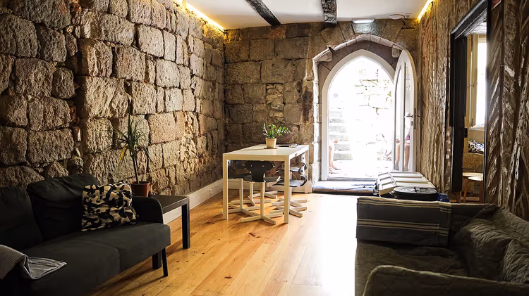 Taş duvarlı ve kanepeli hostel ortak salonu