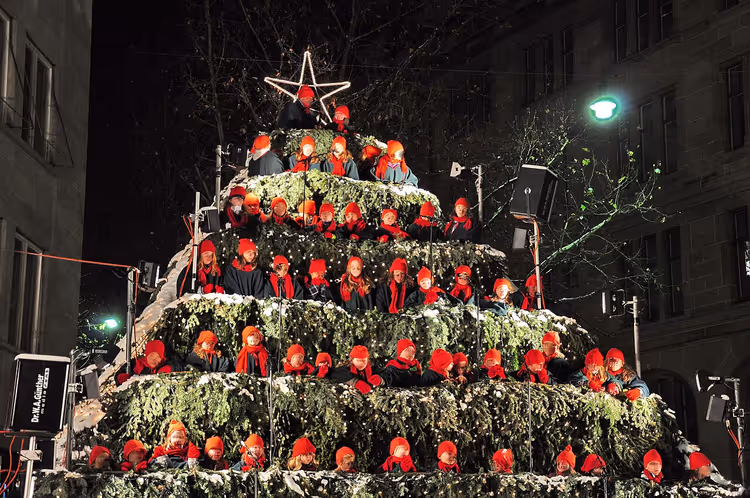 Singender Christbaum mit Kinderchor bei Nacht in Zürich