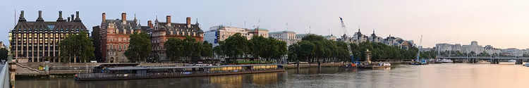 Panorama over Themsen ved Westminster med bygninger langs elvebredden