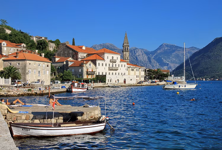 Panorama von Perast mit Uferpromenade, Kirche und Bergen