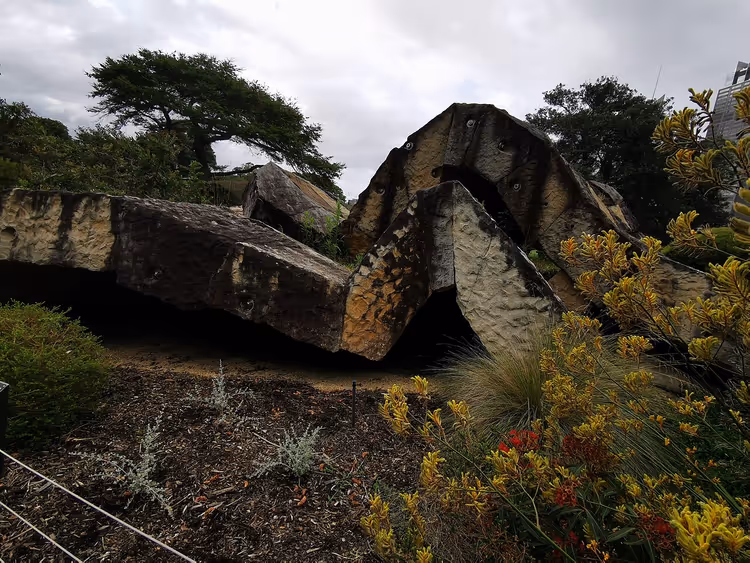 Sandsteinsplatteskulptur i en botanisk hage