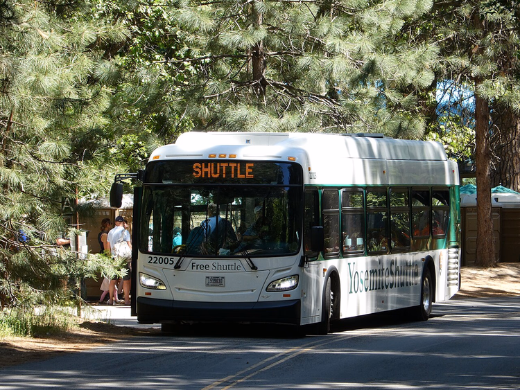 En gratis shuttle i Yosemite Village blant furutrær