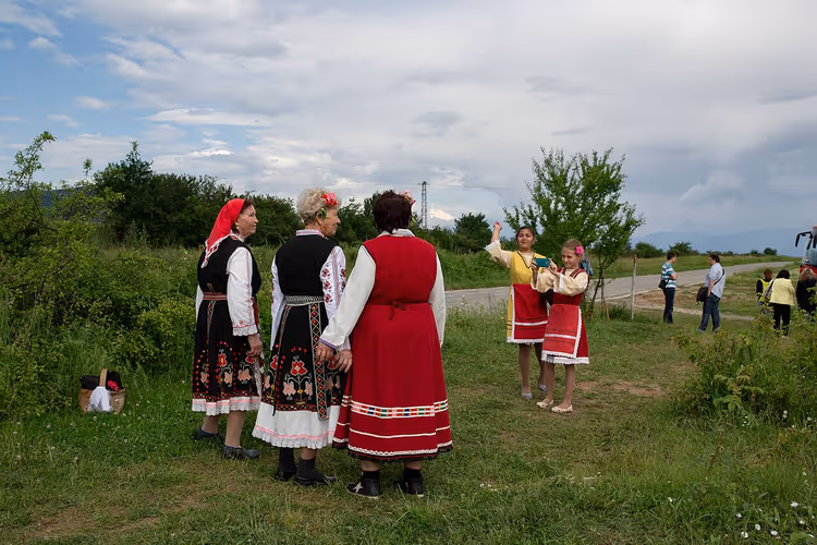 Женщины в болгарских народных костюмах на зелёном лугу