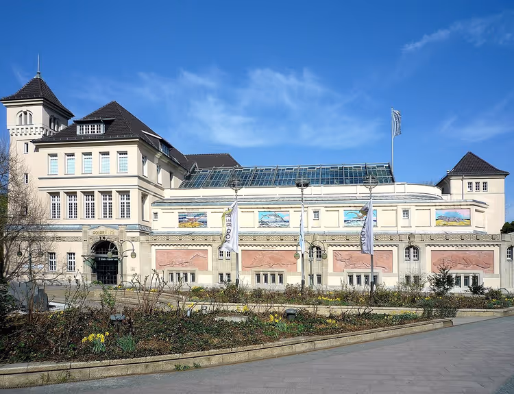 Gevel van het Berlin Aquarium met banners en bloemperken