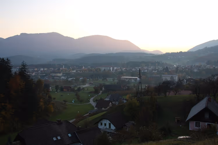 Avondpanorama van het stadje Zreče tussen de heuvels