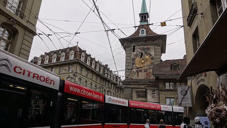 Zytglogge klokketårn over en gate med trikker