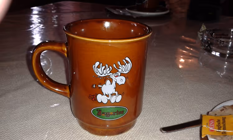 Brun kopp med Jägertee-tekst på et bord