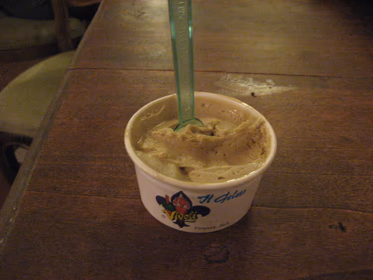 Beker pistachegelato met een groen lepeltje