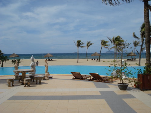 Palmiyelerle plaj kenarındaki tatil köyü havuzu