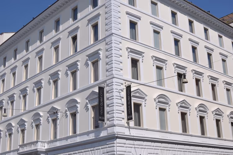 Fachada do edifício branco do Rome Glam Hotel com letreiros