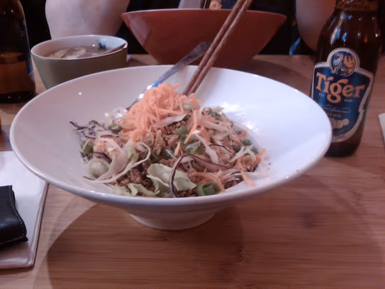 Bowl z sałatką i makaronem, pałeczki oraz piwo Tiger