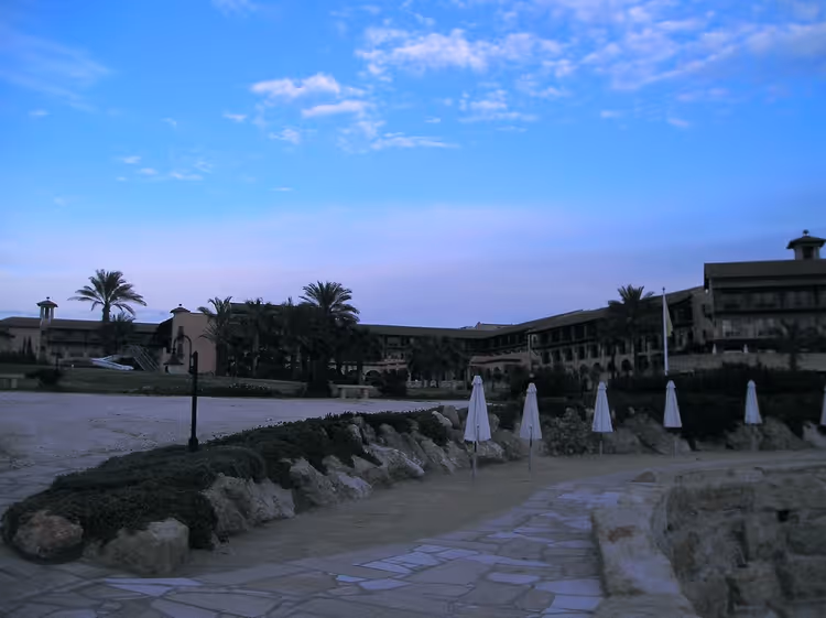 Akşam saatlerinde palmiyeler ve şemsiyelerle Elysium Hotel bahçesi