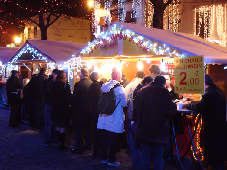 Weihnachtsmarkt bei Nacht mit Ständen und Lichtern