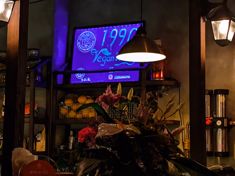 Niebieski szyld 1990 Vegan we wnętrzu restauracji