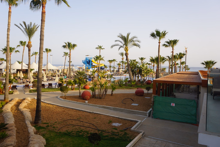Jardins de l'hôtel avec palmiers et vue sur la mer
