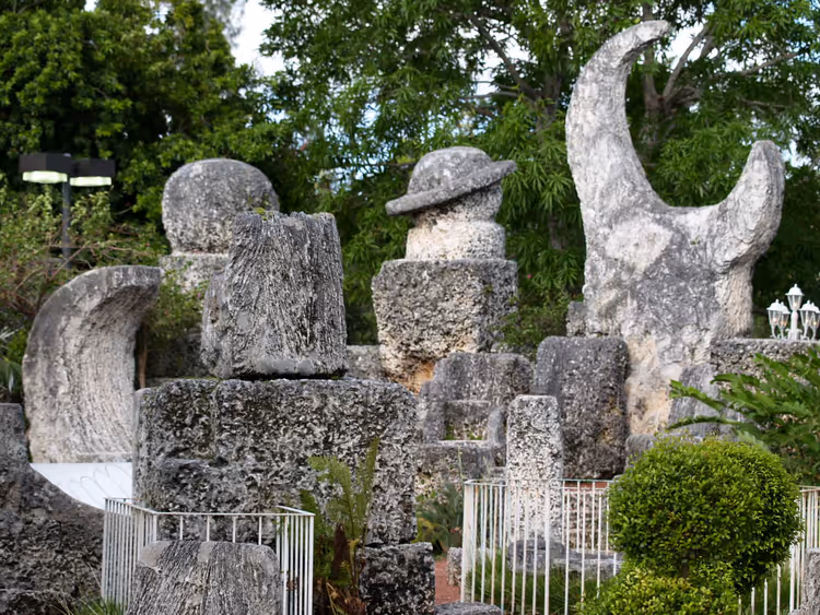 Monolithes de pierre du Coral Castle avec un croissant au milieu de la verdure