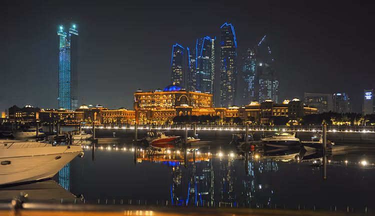 Gece Abu Dabi: Emirates Palace ve marina kıyısındaki gökdelenler