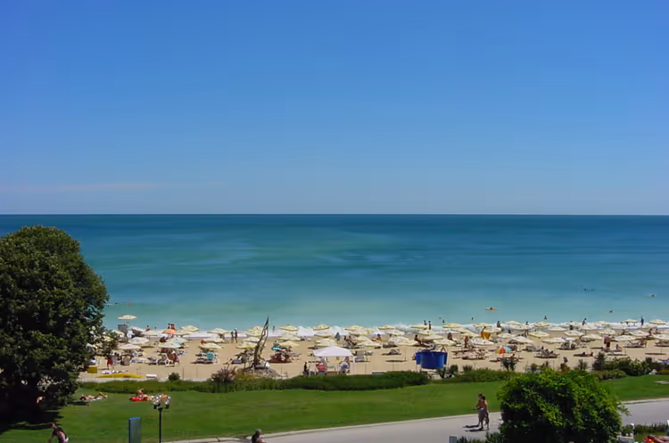 Strand van Golden Sands met parasols in de zomer
