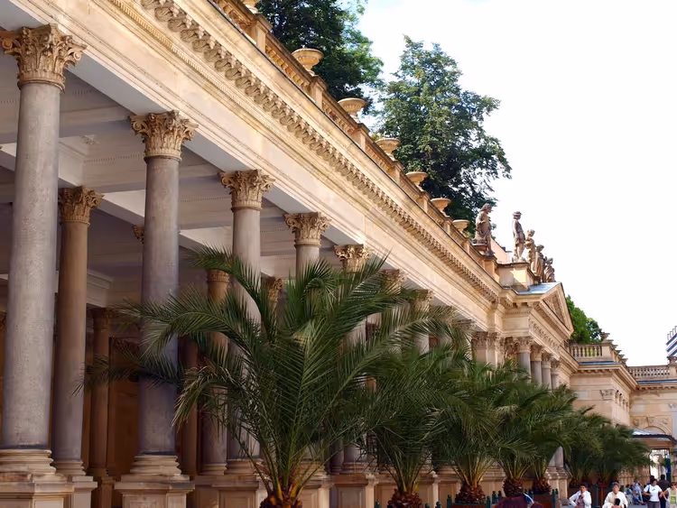 Colonnade met zuilen, palmbomen en standbeelden in Karlovy Vary