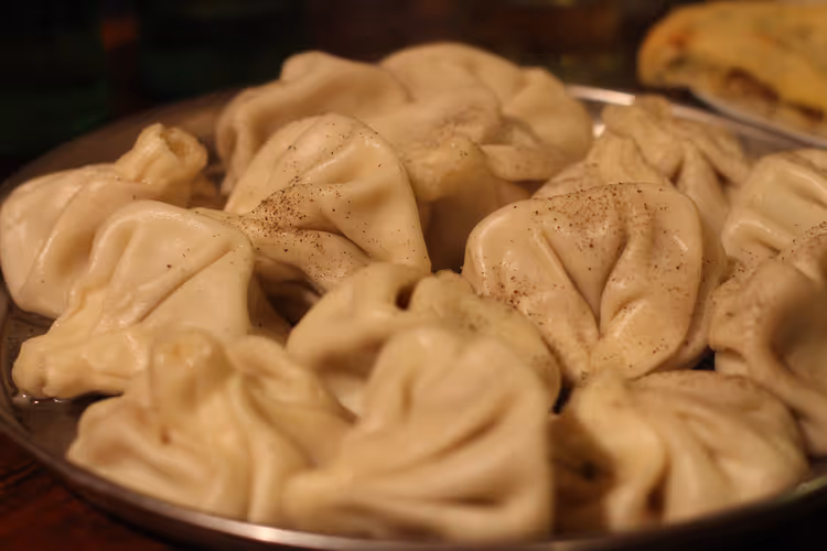 Teller mit heißen Chinkali mit Fleischbrühe