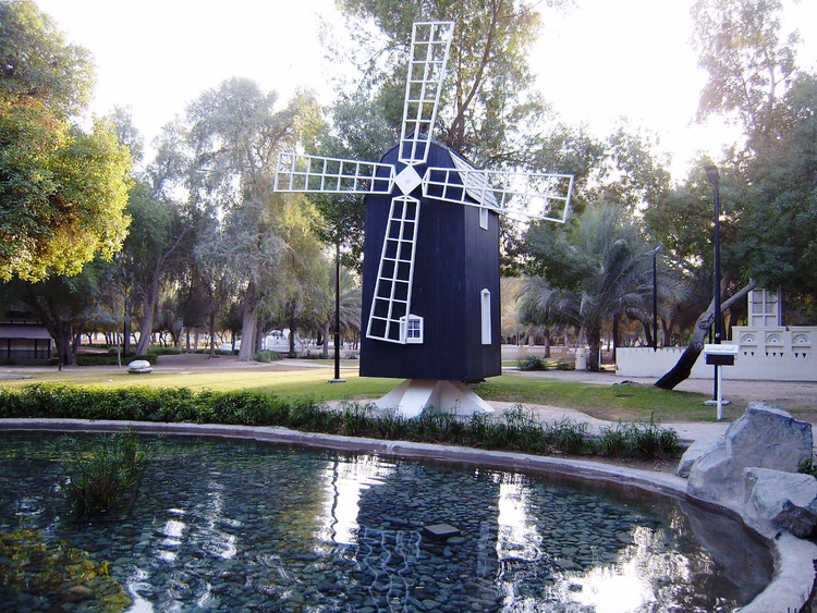 Decoratieve windmolen bij een vijver in Mushrif Park