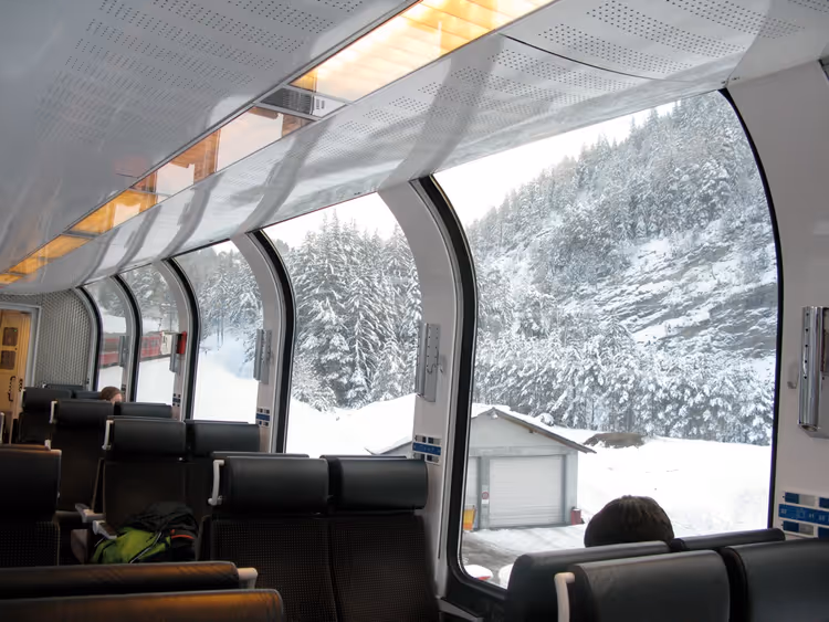 Innenraum eines Panoramawagens mit großen Fenstern und Winterblick