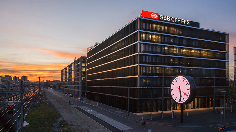 SBB-Hauptsitz neben den Bahngleisen bei Sonnenuntergang