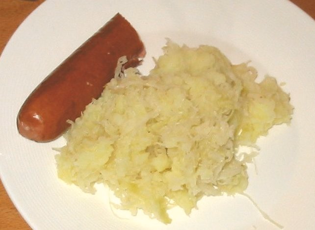 Kartoffeln mit Sauerkraut und Wurst auf einem Teller