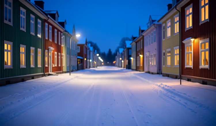 Leere schneebedeckte Straße in einer nordischen Stadt bei Nacht