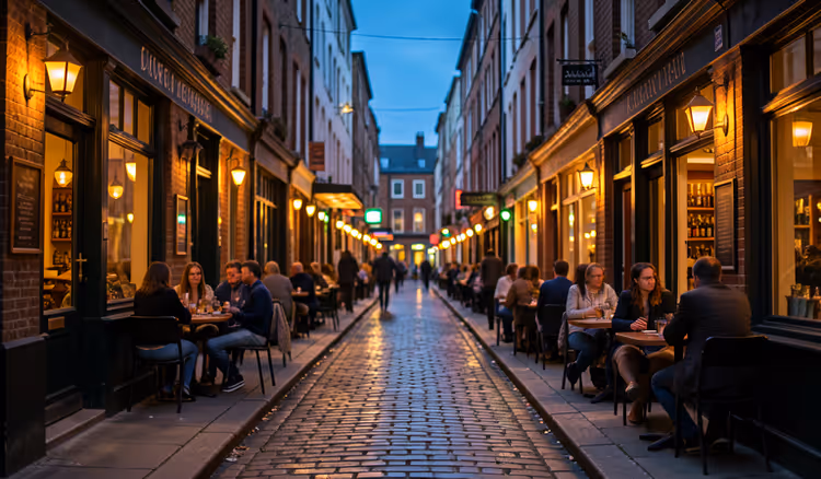 Abendliche Straße mit Bars und Tischen im Freien