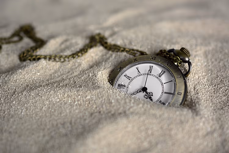 Zakhorloge dat aan een ketting in het zand ligt