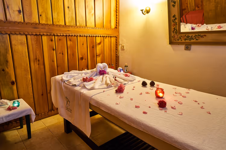 massasjebenk med håndklær og blomster på et spa