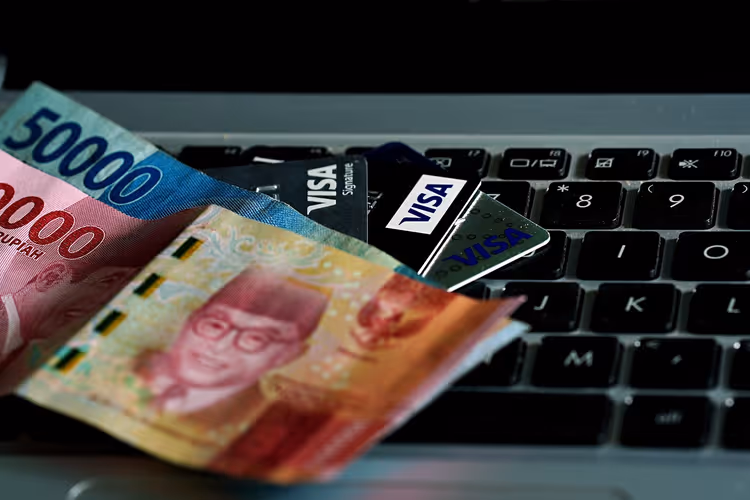 Indonesiska sedlar och Visa-kort på ett tangentbord