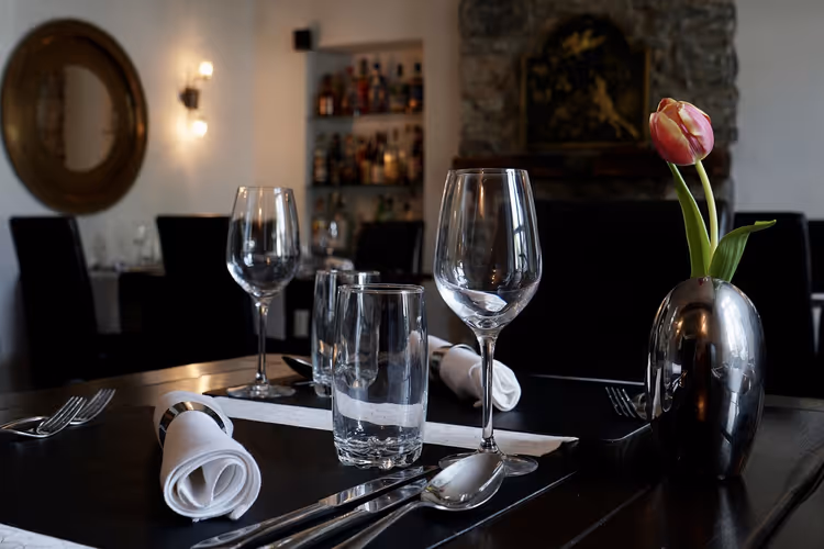 Gedeckter Tisch in einem Pariser Bistro mit Gläsern und einer Tulpe