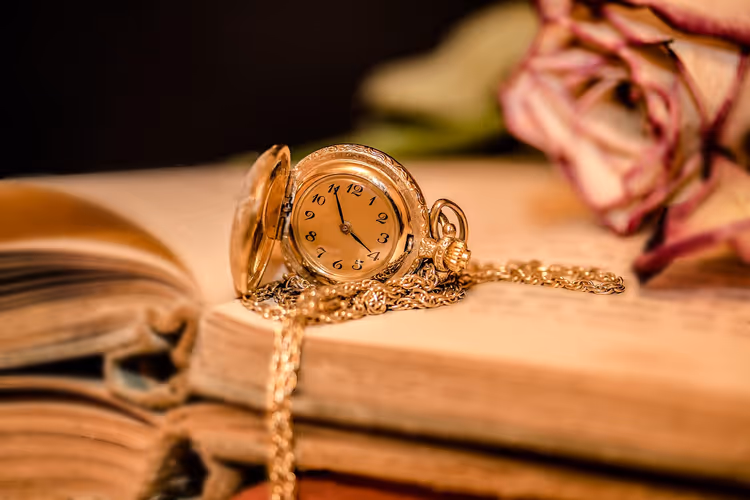 Gouden zakhorloge op een oud boek