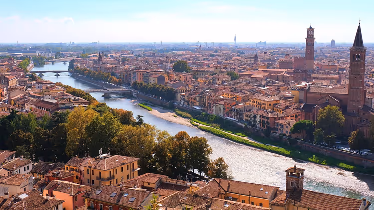 Verona von oben, die Etsch windet sich an Terrakottadächern und hohen Glockentürmen aus Backstein vorbei