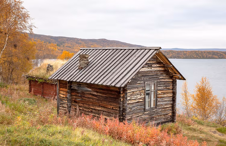 Chalet en rondins au bord d'un lac en automne