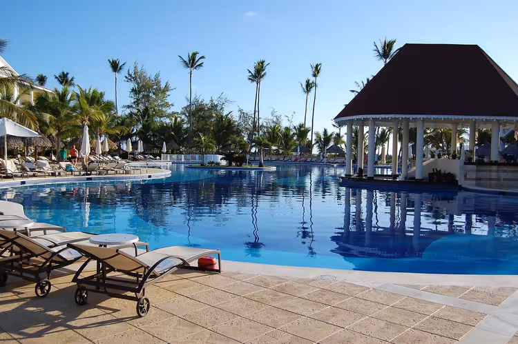 Şezlonglar ve bir gazebo ile tatil köyünün tropikal havuzu