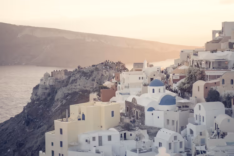 Witte huizen en blauwe koepels van Santorini bij zonsondergang