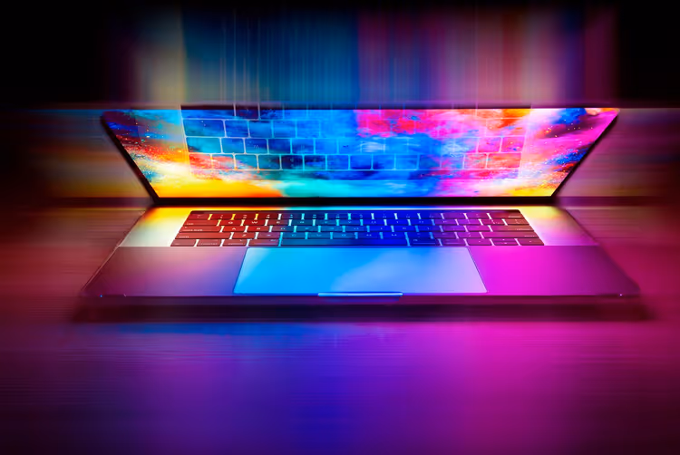 laptop met kleurrijk neonscherm op een donker bureau