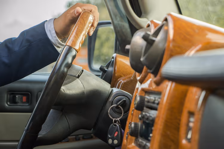 Hand des Fahrers am Lenkrad im Auto